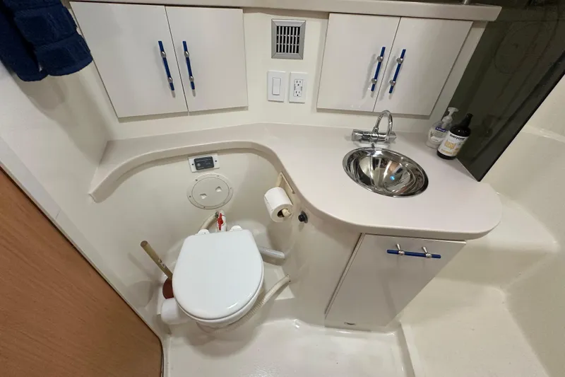 Slide: The Image of Bathroom interior of 1996 Mainship 40 Sedan Bridge with sink, toilet, and storage cabinets. - 31