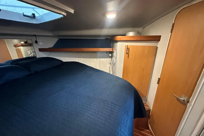 Slide: The Image of 1996 Mainship 40 Sedan Bridge cabin with blue bedding and wooden accents. - 39