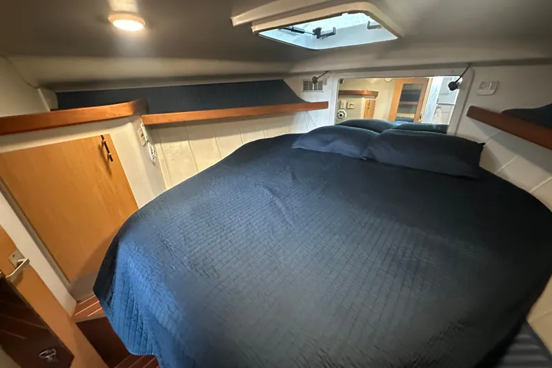 Slide: The Image of Cozy bedroom in 1996 Mainship 40 Sedan Bridge yacht with blue bedding. - 41
