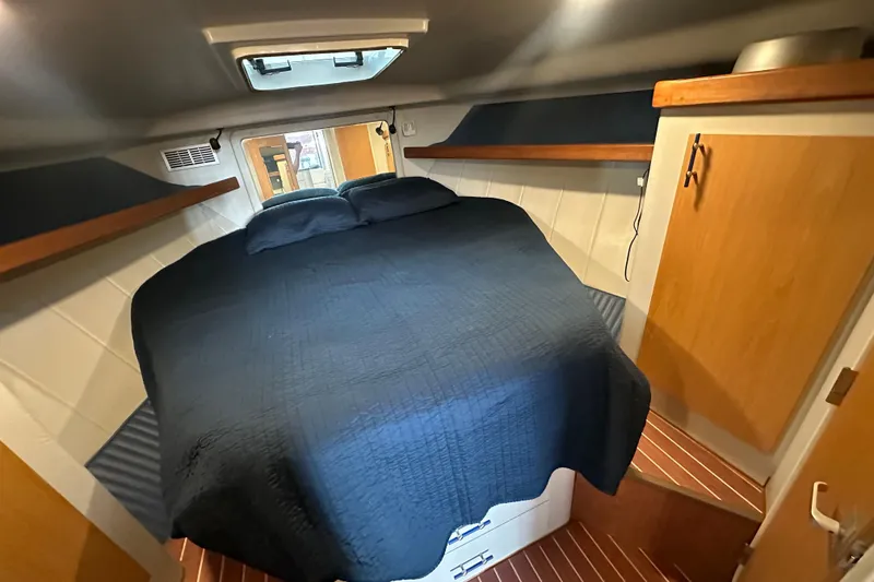 Slide: The Image of 1996 Mainship 40 Sedan Bridge cabin with cozy bed and wooden accents. - 42