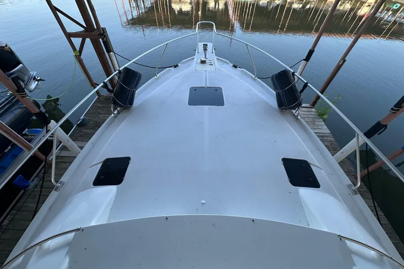 Slide: The Image of 1996 Mainship 40 Sedan Bridge yacht docked, view from the deck, calm water reflection. - 7