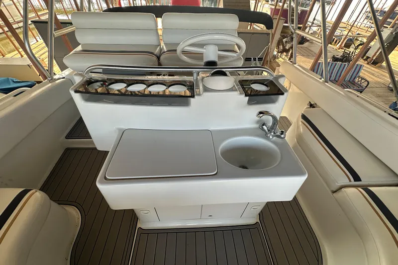 Slide: The Image of 1996 Mainship 40 Sedan Bridge boat deck, docked on calm water. - 8