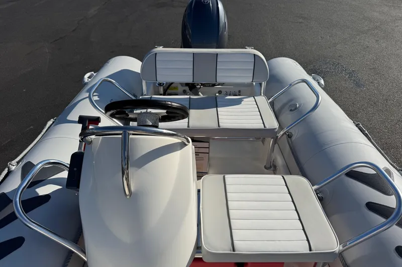 Slide: The Image of 2013 Zodiac 500 Bayrunner inflatable boat with white seating and steering console. - 11