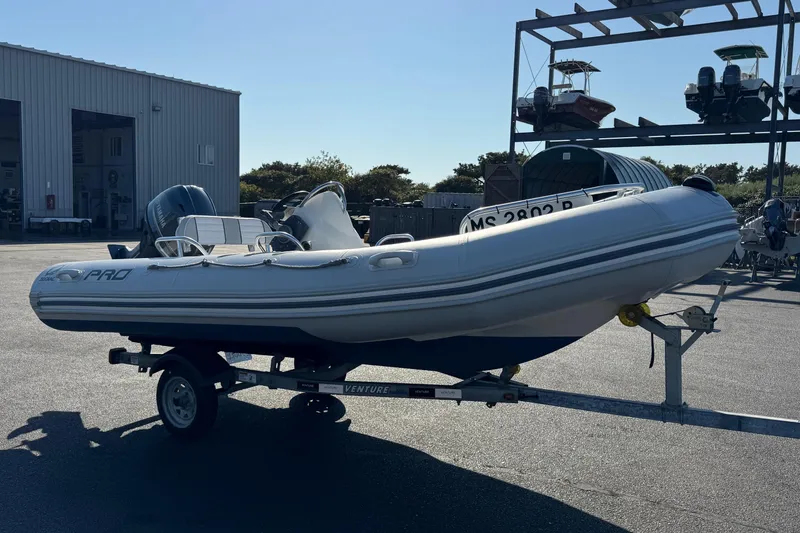 Slide: The Image of 2013 Zodiac 500 Bayrunner inflatable boat on trailer in marina setting. - 3
