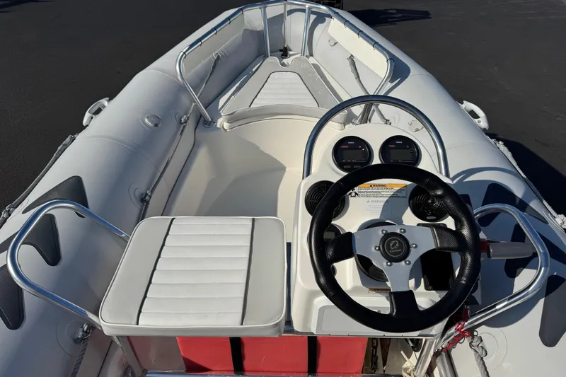 Slide: The Image of 2013 Zodiac 500 Bayrunner boat interior with steering wheel and seating. - 7