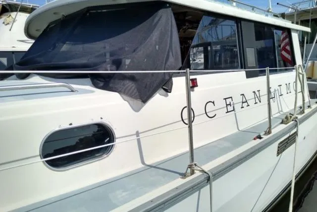 Slide: The Image of 1979 Mainship 34 Custom Sedan docked, featuring "Ocean Limo" lettering on the side. - 1