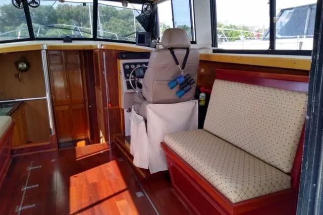 Slide: The Image of 1979 Mainship 34 Custom Sedan interior with wood finish and seating. - 10