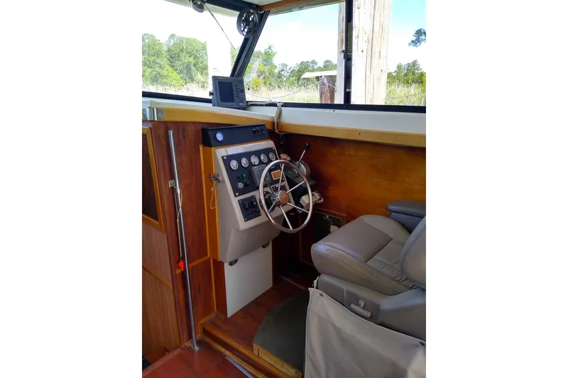 Slide: The Image of 1979 Mainship 34 Custom Sedan helm with steering wheel and navigation equipment. - 12