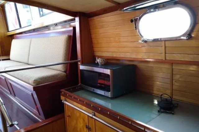 Slide: The Image of Interior of 1979 Mainship 34 Custom Sedan with wood paneling and kitchenette. - 16
