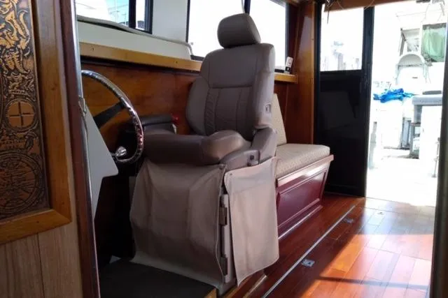 Slide: The Image of Interior of a 1979 Mainship 34 Custom Sedan with a captain's chair and wooden flooring. - 17