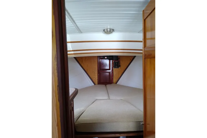 Slide: The Image of 1979 Mainship 34 Custom Sedan cabin interior with cozy bed and wooden accents. - 20