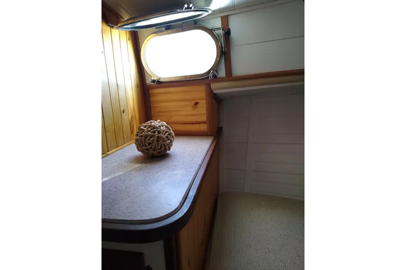 Slide: The Image of 1979 Mainship 34 Custom Sedan interior with wooden paneling and nautical decor. - 22
