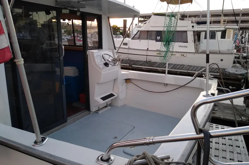 Slide: The Image of 1979 Mainship 34 Custom Sedan docked, showcasing spacious deck and helm area. - 6