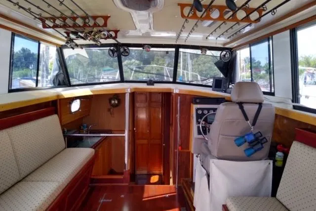 Slide: The Image of Interior of a 1979 Mainship 34 Custom Sedan with fishing rods and seating. - 9