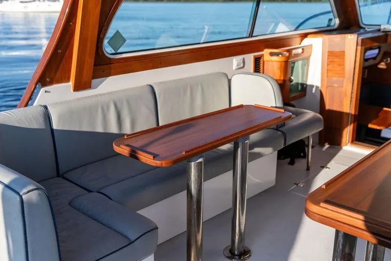 Slide: The Image of Interior of 2012 Hunt Yachts Harrier 36 Express with wooden table and seating. - 13