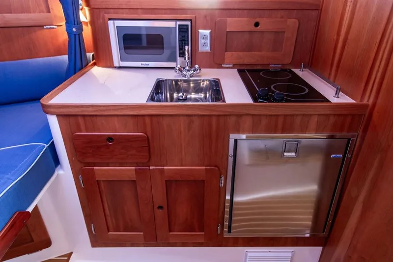Slide: The Image of 2012 Hunt Yachts Harrier 36 Express galley with sink, stove, microwave, and fridge. - 19