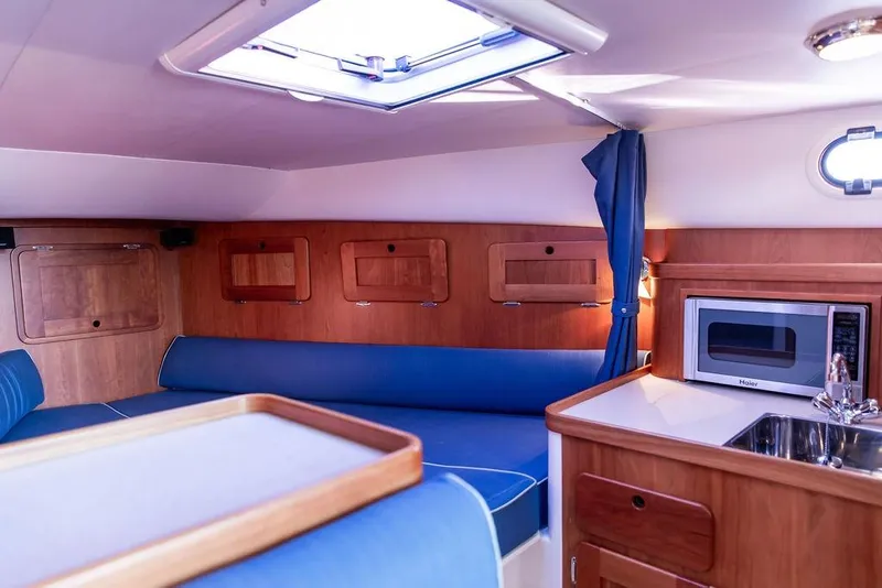 Slide: The Image of Interior of 2012 Hunt Yachts Harrier 36 Express with blue seating and kitchenette. - 21