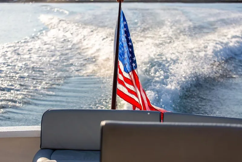 Slide: The Image of 2012 Hunt Yachts Harrier 36 Express with American flag, cruising on open water. - 26