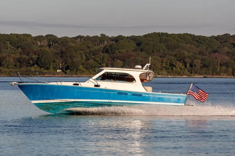 Slide: The Image of 2012 Hunt Yachts Harrier 36 Express cruising on calm water with American flag. - 3