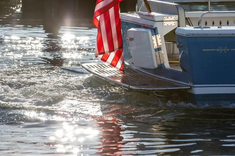 Slide: The Image of 2012 Hunt Yachts Harrier 36 Express with American flag on water, sunlight reflections. - 7