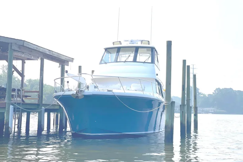 Slide: The Image of 1999 Riviera Convertible SF boat docked on a serene waterfront. - 10