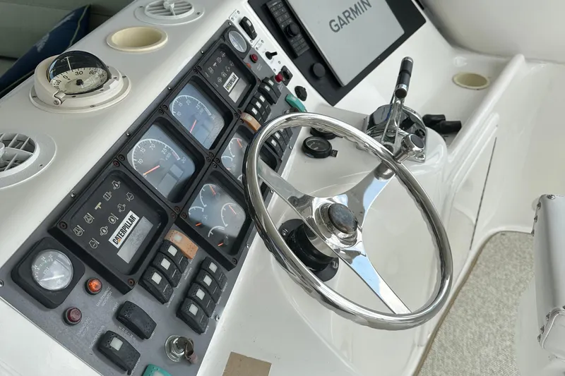 Slide: The Image of 1999 Riviera Convertible SF boat dashboard with steering wheel and navigation instruments. - 13