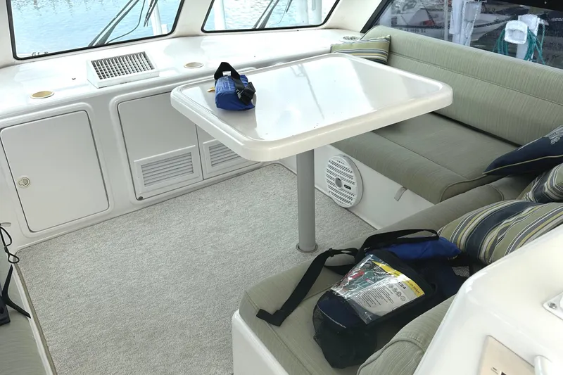 Slide: The Image of Interior of 1999 Riviera Convertible SF yacht with seating, table, and life jackets. - 16