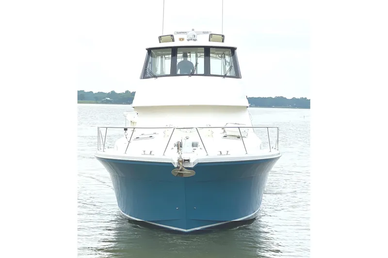 Slide: The Image of 1999 Riviera Convertible SF boat on calm water, front view. - 4