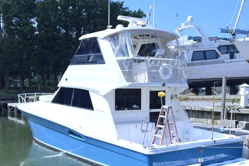 Slide: The Image of 1999 Riviera Convertible SF boat docked, featuring a sleek blue and white design. - 6