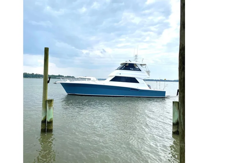 Slide: The Image of 1999 Riviera Convertible SF yacht on calm water under cloudy sky. - 9