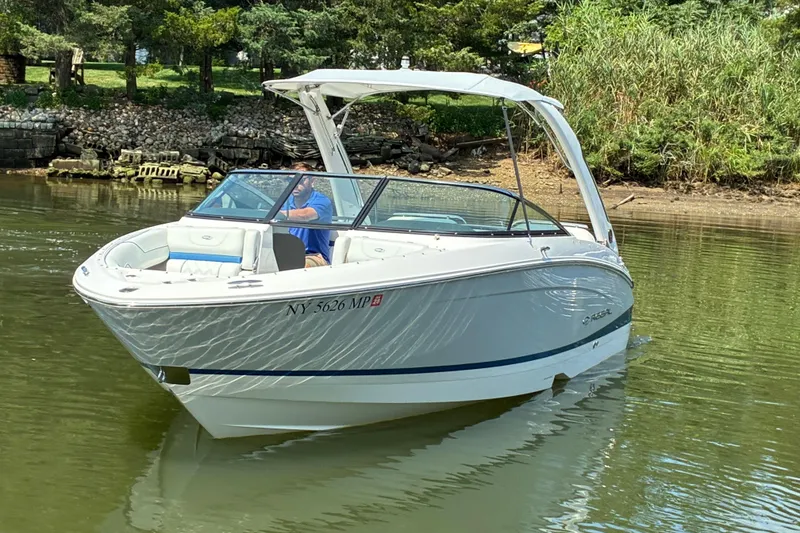 Slide: The Image of 2020 Regal LS4 boat cruising on a calm river with lush greenery in the background. - 2