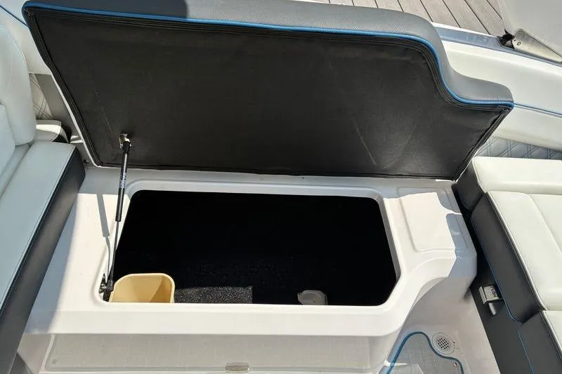 Slide: The Image of Open storage compartment in 2020 Regal LS4 boat with cushioned seating. - 9