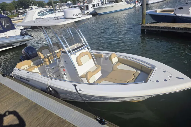 Slide: The Image of 2020 Key West 219 FS boat docked at marina, featuring spacious seating and Garmin equipment. - 19