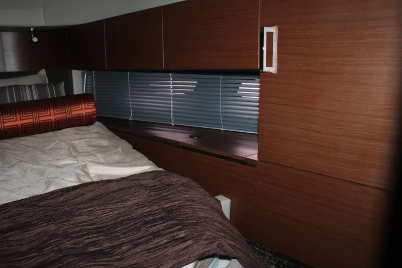 Slide: The Image of Interior cabin of 2015 Sea Ray 470 Sundancer with wooden paneling and bed. - 104