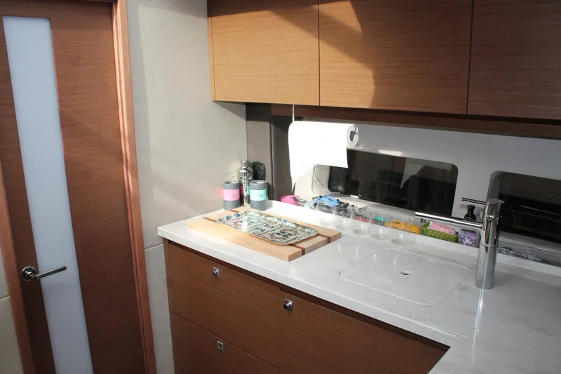Slide: The Image of Modern kitchen interior of 2015 Sea Ray 470 Sundancer yacht with wooden cabinets and countertop. - 107