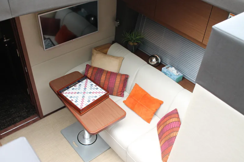 Slide: The Image of Luxurious interior of 2015 Sea Ray 470 Sundancer with cozy seating and game setup. - 112