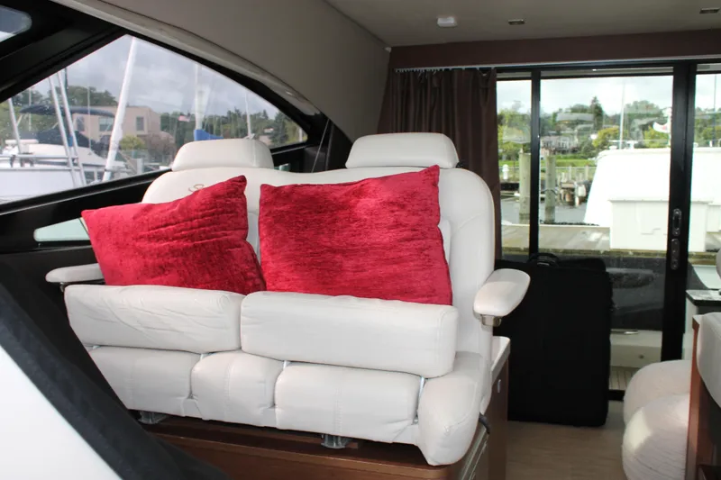 Slide: The Image of Interior of 2015 Sea Ray 470 Sundancer with white seating and red cushions. - 123
