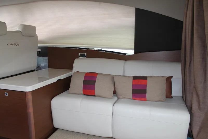 Slide: The Image of Interior of 2015 Sea Ray 470 Sundancer with white seating and colorful cushions. - 132