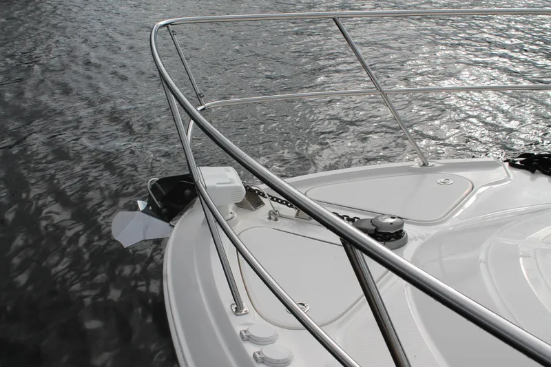 Slide: The Image of 2015 Sea Ray 470 Sundancer bow with stainless steel railings on water. - 135