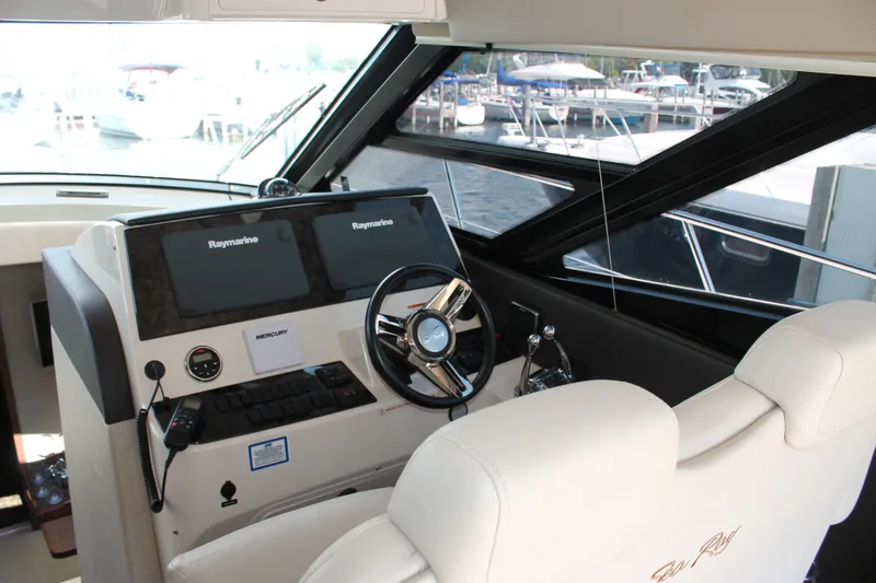 Slide: The Image of Helm of 2015 Sea Ray 470 Sundancer with dual Raymarine displays and leather seating. - 15