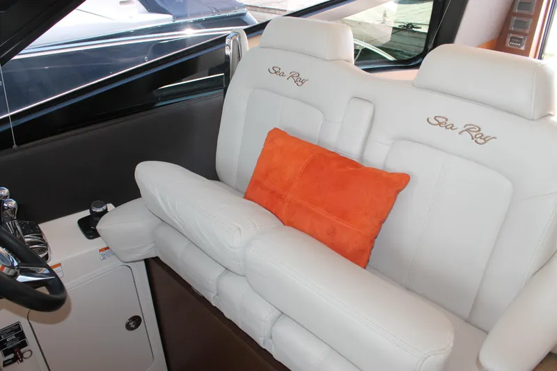 Slide: The Image of 2015 Sea Ray 470 Sundancer interior with white seating and orange cushion. - 17