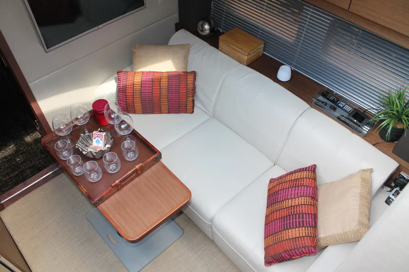 Slide: The Image of Luxurious interior of 2015 Sea Ray 470 Sundancer with white leather seating and wooden table. - 30