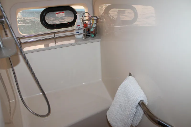 Slide: The Image of 2015 Sea Ray 470 Sundancer bathroom with shower, towel, and window view. - 37
