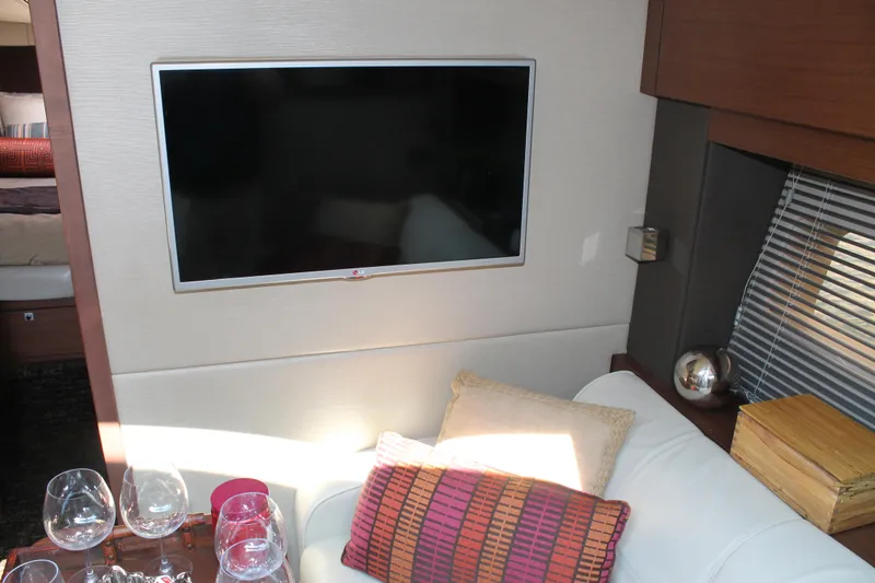 Slide: The Image of Interior of 2015 Sea Ray 470 Sundancer with TV, sofa, and decorative pillows. - 41