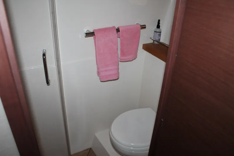 Slide: The Image of Bathroom interior of 2015 Sea Ray 470 Sundancer with pink towels and toilet. - 47