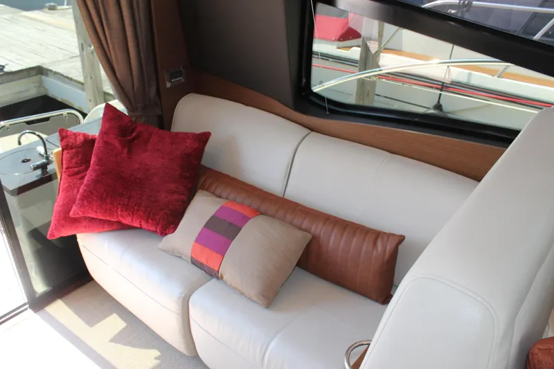 Slide: The Image of Luxurious interior of 2015 Sea Ray 470 Sundancer with plush cushions on a white sofa. - 7