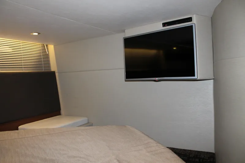 Slide: The Image of Interior of 2015 Sea Ray 470 Sundancer with wall-mounted TV and modern decor. - 91