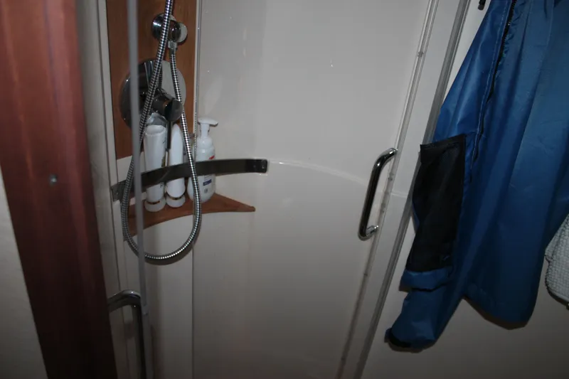 Slide: The Image of Shower area in 2015 Sea Ray 470 Sundancer yacht with toiletries and blue jacket. - 93