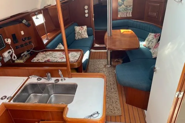 Slide: The Image of Interior of 2003 Beneteau Oceanis Clipper 361 sailboat with cozy seating and wooden finishes. - 18