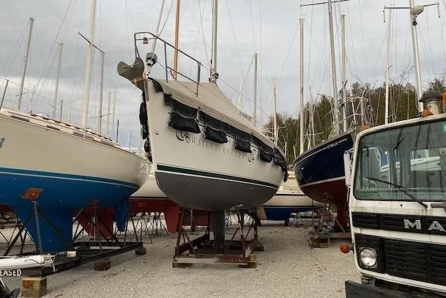 Slide: The Image of 2003 Beneteau Oceanis Clipper 361 sailboat on dry dock, surrounded by other boats and a truck. - 35